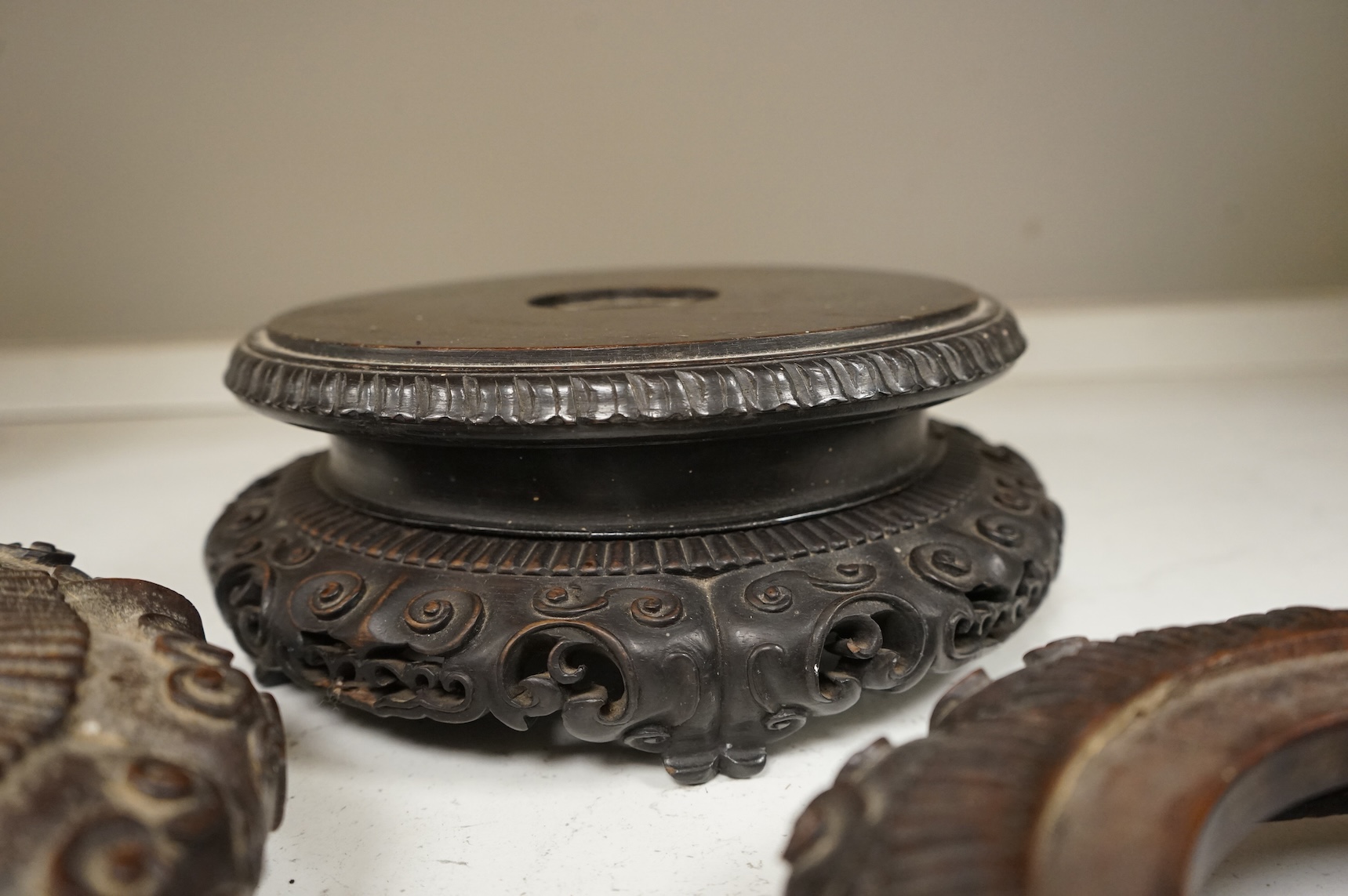 A collection of five Chinese and Japanese carved hardwood stands, late 19th/early 20th century, largest 25cm in diameter